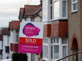 An estate agent's board with a Sold sign attached outside a residential house in Brentwood, U.K., on Monday, Dec. 13, 2021. Asking prices for homes on sale in the U.K. fell for a second month in December, indicating the property market lost momentum at the end of a strong year. Photographer: Chris Ratcliffe/Bloomberg
