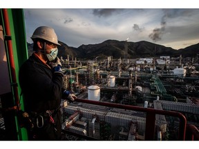An employee looks out from the coker unit over Repsol SA's Cartagena oil refining complex in Cartagena, Spain, on Thursday, Jan. 27, 2022. Oil is headed for a sixth straight weekly gain, with prices trading near a seven-year high as crude makes a roaring start to 2022.