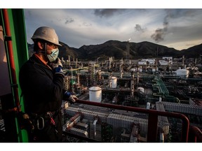 An employee looks out from the coking unit above the Repsol SA oil refining complex in Cartagena, Spain, Thursday, Jan. 27, 2022. Oil is heading for a sixth consecutive weekly gain, with prices trading near from a seven-year high as crude begins 2022 with a bang.