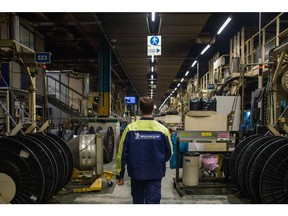An employees walks past reels of rubber on the production line at the Michelin Gravanche manufacturing plant in Clermont Ferrand, France, on Wednesday, Feb. 16, 2022. Michelin said this year will be just as much of a struggle as 2021 as severe bottlenecks in supply chains and transportation routes drive up costs.