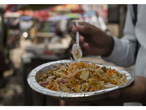 A customer eats a portion of rice 'Biryani' at a roadside food stall in New Delhi, India, on Friday, June 3, 2022. With the world facing mounting food insecurity because of shortages and soaring costs, governments will be watching rice prices for any sign that political unrest is about to erupt. Photographer: Anindito Mukherjee/Bloomberg