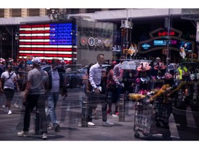 Pedestrians are reflected in a window of the Nasdaq MarketSite in New York, US, on Wednesday, June 15, 2022. Stocks climbed, Treasury yields tumbled and the dollar pushed lower after Federal Reserve Chair Jerome Powell signaled outsized rate hikes will be rare as officials intensify their battle against rampant inflation. Photographer: Michael Nagle/Bloomberg