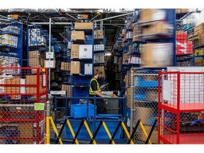 A worker picks product from one of the stacked distribution and storage pods in the warehouse of the Hillside Canadian Tire store in Victoria, British Columbia, Canada, on Monday, July 11, 2022. Canadian Tire operates a network of over 1,700 retail locations.