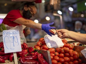 FILE - A customer pays for vegetables at the Maravillas market in Madrid, on May 12, 2022. Inflation figures for Europe will be released Friday, July 1, 2022, as Russia's war in Ukraine has worsened the worldwide surge in consumer prices. For months, inflation in the 19 countries that use the euro has risen at the fastest pace since record-keeping for the currency began.
