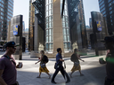 Pedestrians are reflected on a surface outside the Royal Bank of Canada (RBC) head office in Toronto. Canadian bank stocks are paying the price for poor second-quarter earnings from U.S. lenders.