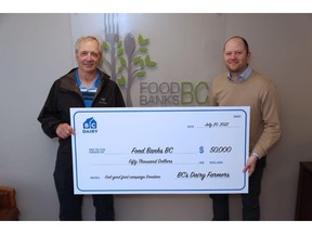 Dan Huang-Taylor, Executive Director of Food Banks BC (right) accepts the $50,000 donation from BC's dairy farmers, presented by Holger Schwichtenberg, Chair of BC Dairy Association (left).