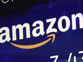 FILE - The logo for Amazon is displayed on a screen at the Nasdaq MarketSite, July 27, 2018. Britain's competition watchdog is planning to investigate whether Amazon is harming competition and hurting consumers by giving an unfair advantage to merchants that pay for extra services.