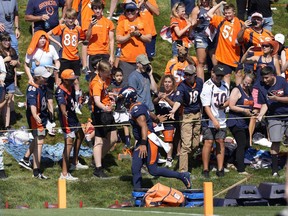 Denver Broncos quarterback Russell Wilson runs along the rope line to greet fans during the opening session of the NFL football team's training camp Wednesday, July 27, 2022, in Centennial, Colo.