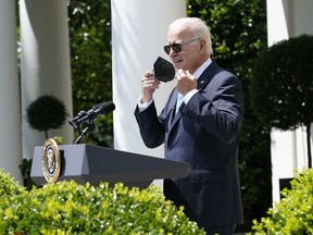 President Joe Biden takes off his mask as he starts to speak in the Rose Garden of the White House in Washington, Wednesday, July 27, 2022. Biden was returning to working in the Oval Office after recovering from COVID-19.