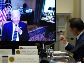 President Joe Biden, on screen at left, listens as SK Group Chairman Chey Tae-won, right, speaks from the Roosevelt Room of the White House in Washington, Tuesday, July 26, 2022. The meeting comes as the Biden administration is seeking the cooperation of Asian allies such as South Korea to reinforce supply chains for critical components such as semiconductors.