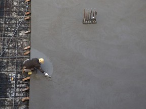 A worker is seen smoothing concrete at a development prior to a news conference at a construction site that will soon house residential housing in Toronto on January 16, 2020. June jobs numbers are set to be released by Statistics Canada on Friday morning. The unemployment in May hit a 39-year-low of 5.1 per cent, with the economy adding 40,000 jobs.