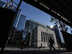 People pass the Bank of Canada building on Wellington Street in Ottawa, on Tuesday, May 31, 2022. A pair of new reports from the Bank of Canada point to rising inflation expectations by Canadian businesses and consumers.
