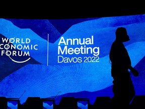 FILE - Workers set the stage prior to the annual meeting of the World Economic Forum, in Davos, Switzerland, Sunday, May 22, 2022. The World Economic Forum reported on Wednesday, July 13, 2022, that the cost-of-living crisis, sparked in part by higher fuel and food prices, is expected to hit women the hardest.