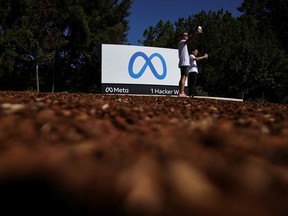 People take selfies in front of Meta's headquarters in Menlo Park, California.