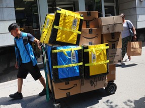 Ein Mitarbeiter von Amazon.com Inc. zieht einen Wagen mit Paketen für die Lieferung in New York City.