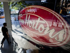 A pedestrian walks past a Tim Hortons Inc. restaurant in downtown Vancouver.