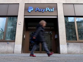 A pedestrian walks past the PayPal logo at an office building in Berlin, Germany.