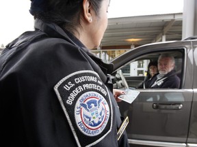 Ein US-Zoll- und Grenzschutzbeamter spricht mit einem Paar, das NEXUS-Ausweise an einem Grenzübergang von Kanada in die USA in Blaine, Washington, verwendet.
