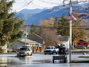 A person drives through flood waters after rainstorms that hit both British Columbia and Washington state caused flooding on both sides of the border, in Sumas, Washington.