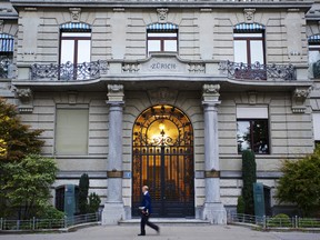 A pedestrian walks past Zurich Insurance Group AG's headquarters in Zurich, Switzerland.