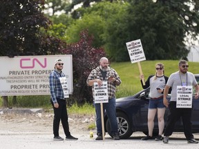 CN rail workers strike at the CN MacMillan Yard in Vaughan, Ont., on Monday, June 20, 2022. Canadian National Railway Co. says a strike by 750 signals and communications workers will end early Tuesday after the International Brotherhood of Electrical Workers agreed to binding arbitration.