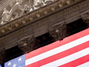 FILE - An American flag adorns the facade of the New York Stock Exchange on June 29, 2022, in New York. Stocks are opening broadly higher on Wall Street Tuesday, July 19, 2022, as more earnings reports roll in from U.S. companies.