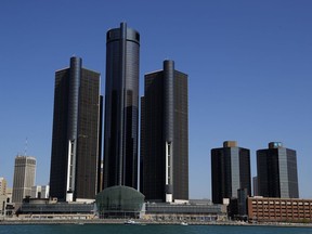 FILE - This May 12, 2020, file photo, shows a general view of the Renaissance Center, headquarters for General Motors, along the Detroit skyline from the Detroit River. General Motors will keep its headquarters in the sparsely populated seven-building office tower complex says CEO Mary Barra.