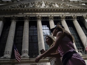 FILE - Pedestrians walk past the New York Stock Exchange, July 8, 2022, in New York. Stocks are opening higher on Wall Street ahead of another busy week of earnings from U.S. companies. Banks were among the winners in the early going Monday, July 18, 2022.