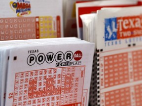 FILE - A playslip for the Power Ball lottery sits in a holder at a convenient store in Dallas, Texas, Thursday, March 26, 2020. State lotteries spend more than a half-billion dollars a year on pervasive marketing campaigns that deliver hopeful messages, designed to persuade people to play often, spend more and overlook the long odds of winning. But for every dollar players spend on the lottery, they will lose about 35 cents on average, according to an analysis of lottery data by the Howard Center for Investigative Journalism at the University of Maryland.