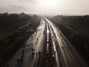 Commuters walk along the Pan American Highway due to roadblocks set up by protesters demonstrating against inflation, especially surging fuel prices, in Pacora, Panama, early Wednesday, July 20, 2022.