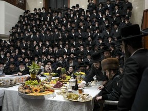 FILE - Ultra-Orthodox Jews of the Sadigura Hasidic dynasty celebrate the Jewish feast of 'Tu Bishvat' or "New Year of the Trees." as they sit with their rabbis around a long table filled with all kinds of fruits, in the ultra-Orthodox town of Bnei Brak, Israel, Sunday, Jan. 16, 2022. In April 2022, the country's communications minister made it easier for the Haredi, or ultra-Orthodox, community, to use the devices without the knowledge of their rabbis, raising tensions within the Haredi community and between them and the rest of Israeli society.