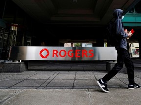 A person walks past the Rogers Communications' building in Toronto.