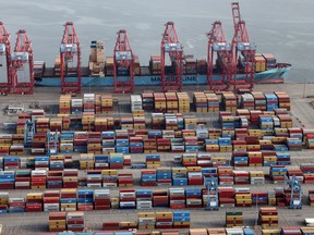 Shipping containers are uploaded from a ship at a port in California.