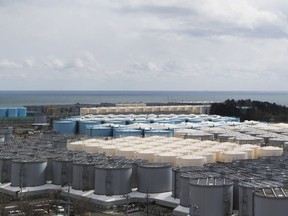 FILE - This photo shows tanks (in gray, beige and blue) storeing water that was treated but is still radioactive after it was used to cool down spent fuel at the Fukushima Daiichi nuclear power plant in Okuma town, Fukushima prefecture, northeastern Japan, on Feb. 27, 2021. Japan's nuclear regulator on Friday, July 22, 2022, approved the release of treated radioactive wastewater from the wrecked Fukushima nuclear power plant into the sea next year.