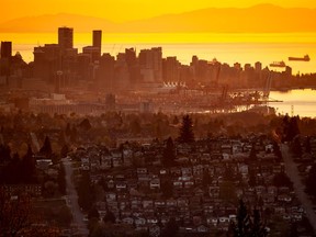 Houses line a hillside overlooking the Vancouver skyline. Home prices here in June were down two per cent from the month.