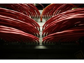 Rows of colored high end data cables are seen feeding into computer servers inside a comms room at a office in London, U.K., on Tuesday, Dec. 23, 2014. Vodafone Group Plc will ask telecommunications regulator Ofcom to guarantee that U.K. wireless carriers, which rely on BT's fiber network to transmit voice and data traffic across the country, are treated fairly when BT sets prices and connects their broadcasting towers. Photographer: Bloomberg/Bloomberg