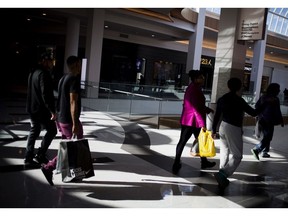 Shoppers carry bags while walking at the Roosevelt Field Mall in Garden City, New York.