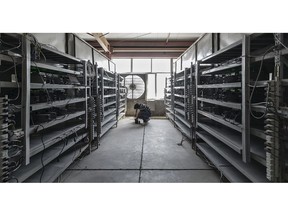 A technician inspects bitcoin mining machines at a mining facility in Ordos, Inner Mongolia, China.