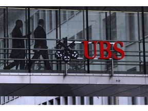 Employees pass between offices as UBS Group AG logo sits on a walkway at the UBS headquarters in Zurich, Switzerland, on Monday, Jan. 22, 2018. A UBS loan backed by shares of Steinhoff International Holdings NV was to blame for the majority of the Swiss bank's 79 million francs ($82 million) in credit losses in the fourth quarter, a person with knowledge of the matter said. Photographer: Stefan Wermuth/Bloomberg