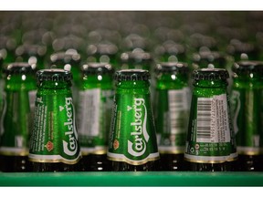 Green bottles of Carlsberg beer move along the production line following the labeling process at the Baltika Breweries LLC plant, operated by Carlsberg A/S, in Saint Petersburg, Russia, on Thursday, May 10, 2018. A slowdown in Russian demand for beer as international sanctions threaten the country's economy is weighing on Danish brewer Carlsberg's sales. Photographer: Andrey Rudakov/Bloomberg