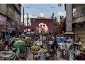 Rickshaw pullers and market vendors gather outside the Ahsan Manzil, the former official residential palace and seat of the Nawab of Dhaka, in Dhaka, Bangladesh, on Wednesday, June 6, 2018. The Bangladesh economy will expand 6.9% this financial year and 6.8% in 2019, according to a survey conducted by Bloomberg News. Photographer: Ismail Ferdous/Bloomberg