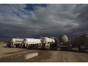 Tanker trucks sit on a gravel median waiting to be dispatched to drill sites in the Permian Basin area of Loving County, Texas, U.S., on Monday, Dec. 17, 2018. Once the shining star of the oil business, gasoline has turned into such a drag on profits that U.S. refiners could be forced to slow production in response.