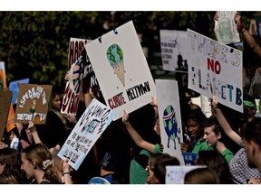 Protesters hold signs during a Global Climate Strike demonstration in Washington, D.C., U.S., on Friday, Sept. 20, 2019. A global protest movement backed by 16-year-old activist Greta Thunberg got underway Friday, with tens of thousands of people across Asia, Africa and Europe demanding action on climate change.