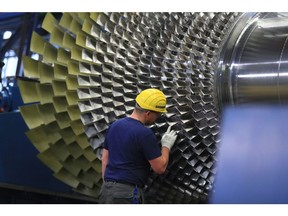 Siemens Gas Turbine plant in BerlinEmployee checks the lades of a Simens SGT5-4000F gas turbine. Berlin, Germany04.12.2019.Photo: Krisztian Bocsi