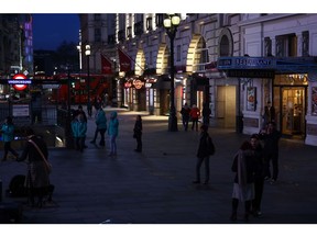 Pedestrians walk through Piccadilly Circus in the West End district in London, U.K., on Friday, March 20, 2020. A shutdown of the U.K. capital would hit the night-time economy hard -- one in three employees in London works between 6 p.m. and 6 a.m., many in the pubs, restaurants and clubs most at risk of survival because of the pandemic. Photographer: Simon Dawson/Bloomberg