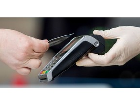 A customer uses a bank card to make a contactless payment at a market stall in Norwich, UK, Tuesday, June 9, 2020. As the economy is on course for its deepest recession in at least a century, the government now pays the wages of more than 10 million workers to avoid mass unemployment. Photographer: Chris Ratcliffe/Bloomberg