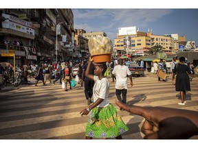 A girl carries corn husks on her head in Kampala, Uganda, on Thursday, July 23, 2020. Uganda's economy will probably expand at the slowest pace in more than three decades this year due to the fallout from the coronavirus pandemic, a locust invasion and floods, the World Bank said.
