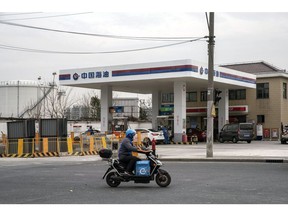 A motorist travels past a Cnooc Ltd. gas station in Shanghai, China, on Thursday, Jan. 7, 2021. China's energy markets are tightening as the economy rebounds and freezing weather grips much of the northern hemisphere, a dynamic that's likely to be exacerbated by reduced Saudi oil output. Photographer: Qilai Shen/Bloomberg