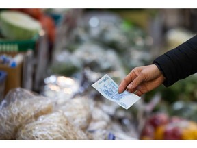 A customer holds a South Korean 1,000 Won banknote at a vegetable stall in Mangwon Market in Seoul, South Korea, on Tuesday, Feb. 9, 2021. South Korea relaxed its social distancing rules on Monday, allowing longer opening hours for some retail businesses, as the number of new coronavirus infections declines. Photographer: SeongJoon Cho/Bloomberg