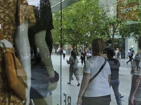 Shoppers and pedestrians are reflected in a store window at Rundle Mall in Adelaide, Australia, on Thursday, Feb. 11, 2021. Melbourne Institute of Applied Economic and Social Research said today that Australian consumers expect prices will rise 3.7% over the next 12 months. Photographer: James Bugg/Bloomberg